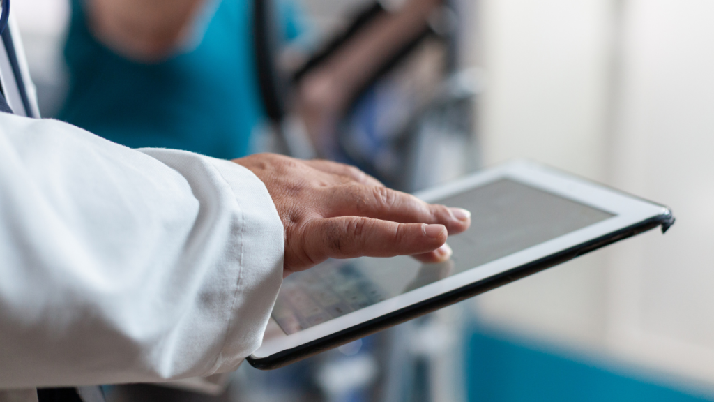 Médico utilizando um tablet com MDM para gerenciar dados de pacientes.